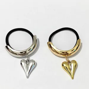 Detailed view of stylish metal heart hair tie, glossy alloy elastic hair rope in gold and silver.