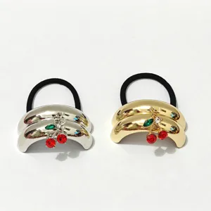 Detail shot of metallic dome hair ties with crystal cherry charms, silver and gold options.