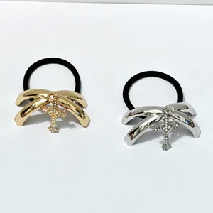 Glossy alloy hair tie with sparkling rhinestone cross pendant, stylish metallic hair accessory.