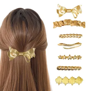 Detail shot of golden bow and various geometric hair clips showcasing fine texture and design.