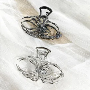 Detailed close-up view of gothic spider hair claw clips with pearls and rhinestones design.