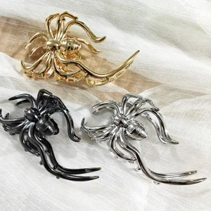 Close up of metallic spider hair claw clips in gold, black and silver. Detailed styling.
