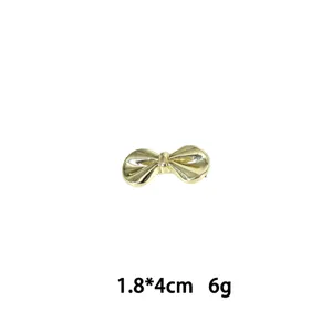 Detailansicht der goldenen Metall-Schleifen-Haarspange, kompakte Größe, elegantes Accessoire.