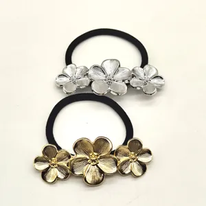 Detailed close-up of metal flower hair ties set, featuring elegant silver and gold floral design.