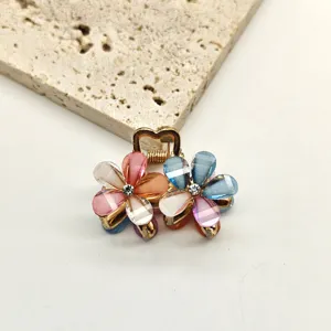 Detailed shot of a mini crystal flower hair claw clip with colorful petals and rhinestones.
