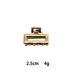 Detail view of mini gold metal hair claw clip, 2.5cm rectangular hollow design accessory.