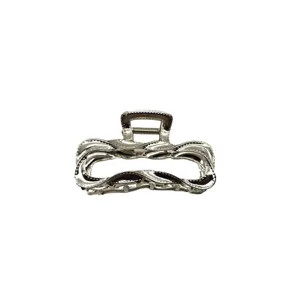 Pinza para el pelo de metal plateado con diseño hueco ondulado para peinados elegantes.