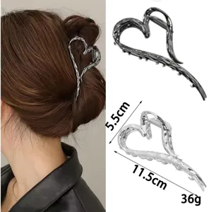 Detail view of the abstract liquid metal heart hair claw clip, showing dimensions and wear.