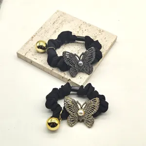 Detailed close-up of crystal butterfly hair scrunchie with metal ball pendant for daily hair styling.