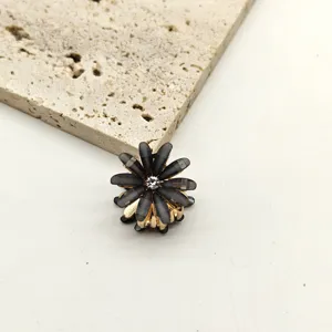 Mini black flower hair claw clip with sparkly crystal center for cute side bangs styling.
