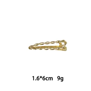 Detailaufnahme einer goldenen Metall-Haarspange mit geflochtenem Design und Maßen.
