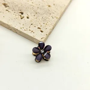 Detail shot of mini purple flower hair claw clip with crystal center for side styling.