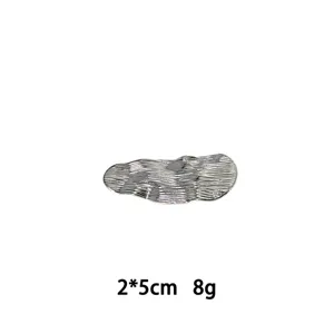 Detailansicht der unregelmäßig strukturierten Metall-Haarspange mit feinem Wellendesign.