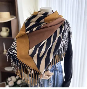 Close up detail of a stylish color block zebra pattern fringed scarf draped elegantly.