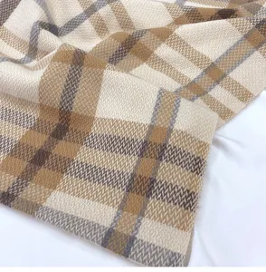 Detailed close-up view showing the soft texture of the classic camel plaid winter scarf.