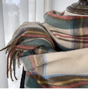 Close-up detail of winter soft imitation cashmere plaid scarf with cozy tassels for women.