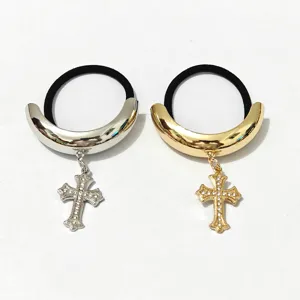 Alloy high-gloss hair tie with metal crescent and rhinestone cross pendant detail close-up.