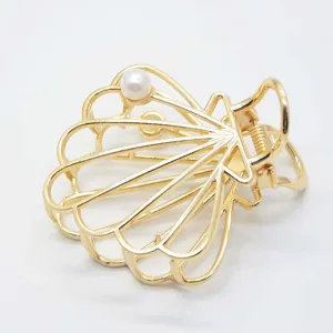 Gold metal hair claw clip featuring shell design and pearl accent for daily styling details.