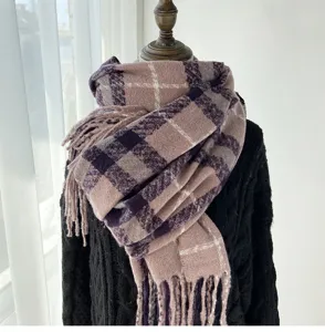 Close-up detail of knitted plaid winter scarf with fringe, soft warm texture and cozy style.