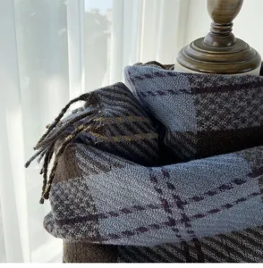 Détail d'écharpe tricotée à carreaux d'hiver douillette, franges douces et chaudes tons marron bleu.
