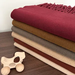 Detailed shot of cozy winter cashmere-feel solid color scarf with soft elegant tassels.
