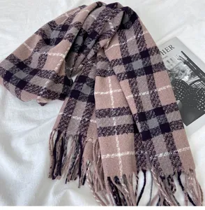 Detailed view of the women's cozy winter plaid scarf with stylish tassels and warm fabric.