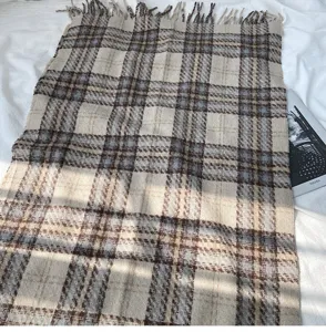 Detailed view of winter plaid cashmere-feel scarf, soft texture with elegant fringe trim.