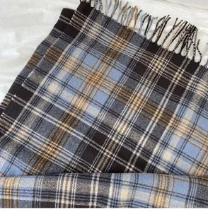Classic blue plaid winter scarf detail, soft warm woven fabric with elegant fringe tassels.