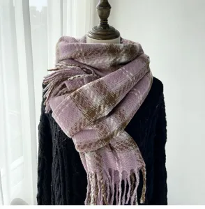 Close-up detail of the stylish pink and brown plaid winter scarf with cozy fringe.