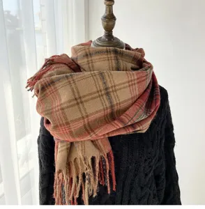 Close-up detail of cozy autumn winter plaid tassel scarf, soft vintage warm fabric.