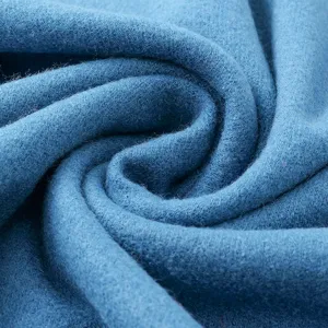Close-up fabric detail of soft blue cashmere-feel winter scarf, warm and cozy knit texture.