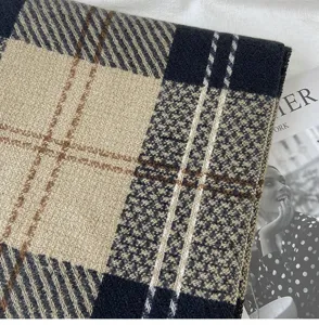 Détail d'écharpe à carreaux d'hiver épaisse, design pied-de-poule noir et beige confortable.