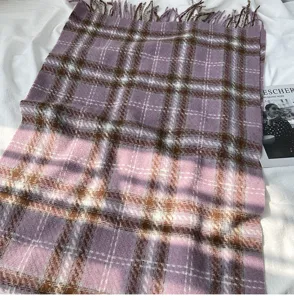 Close-up detail of cozy purple plaid imitation cashmere scarf with elegant fringe trim.