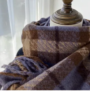 Close-up detail of thickened warm plaid scarf, showing soft fabric texture and warm tones.