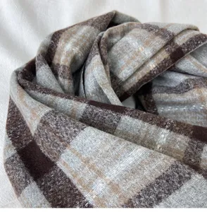 Detailed close-up of the cozy brown and grey plaid cashmere-feel winter scarf texture.