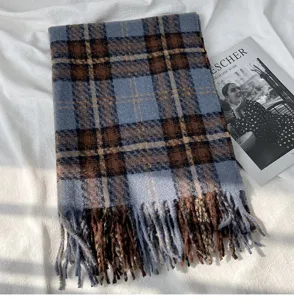 Detailed view of the cozy blue and brown plaid scarf featuring soft fringe and warm texture.