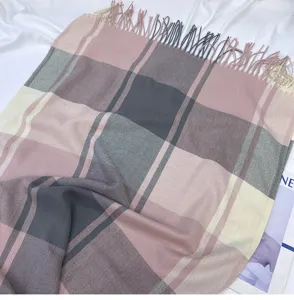 Detailed view of the women's pink and grey plaid winter scarf with elegant fringe design.