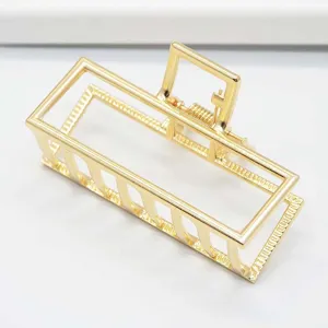 Golden minimalist rectangular metal hair claw clip detail shot for elegant daily hairstyles.