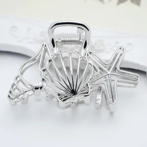 Silver metal hair claw clip featuring ocean shell and starfish design close-up details.