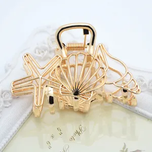 Golden metal hair claw clip detail featuring seashell and starfish design for elegant hairstyles.