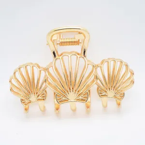 Detailed view of golden zinc alloy triple shell hair claw clip for elegant styling.