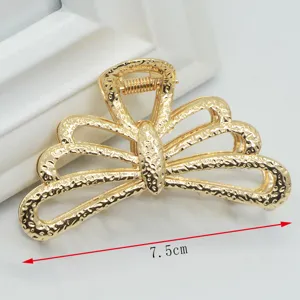 Close-up detail of the elegant gold metal hair claw clip featuring a stylish hollow design.