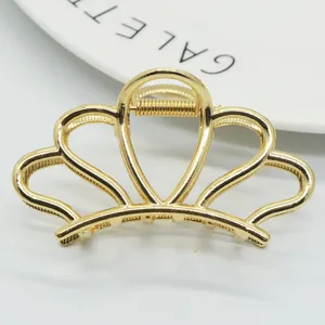 Gold metal hair claw clip featuring an elegant crown design, perfect hair accessory detail.