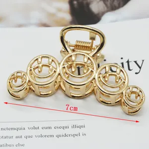 Minimalist gold metal hair claw clip with hollow smiley face design, large size accessory.