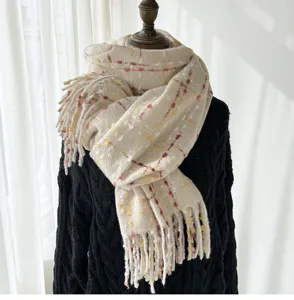 Detail shot of women's beige plaid fringe scarf, soft cashmere-feel winter warm accessory.