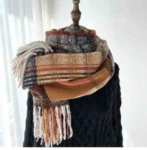 Detail view of winter warm plaid tassel scarf, cozy thick fabric for cold days.