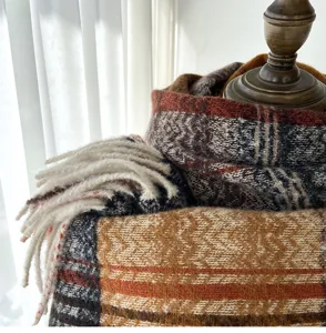 Detail view of cozy winter knitted plaid tassel scarf with warm texture and classic retro pattern