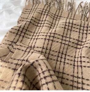 Gros-plan détail d'hiver écharpe à carreaux montrant une texture douce et franges.