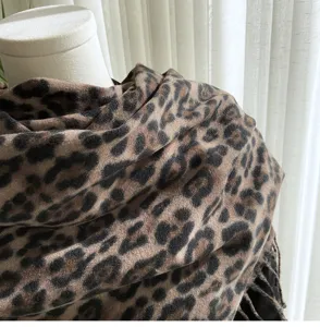 Close-up detail of classic leopard print winter fashion scarf with soft texture and chic fringe.