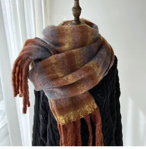Gros plan detaille sur une douce et chaude echarpe en mohair carreaux avec belles franges.